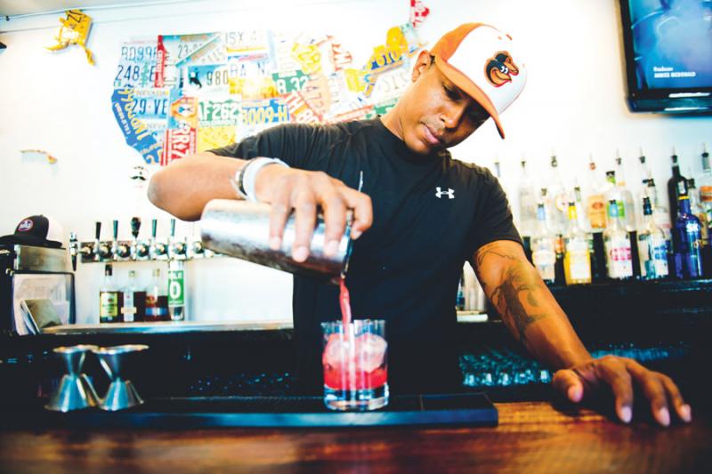Bartender Omar Dupree pours a cocktail. 