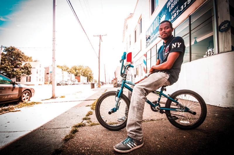 A young man on a bike stops for a breather on Patapsco Ave.