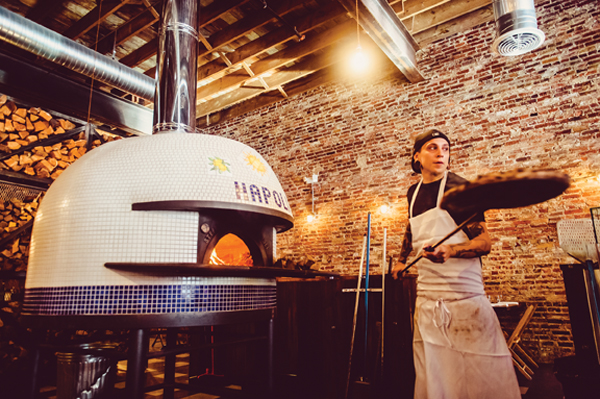 Whitleigh “Pizza Daddy” Higuera of Paulie Gee’s carries a pie fresh from the wood-fired oven.