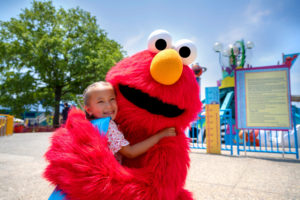 Elmo hugs a child at Sesame Place Philadelphia
