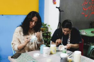 People painting pottery together