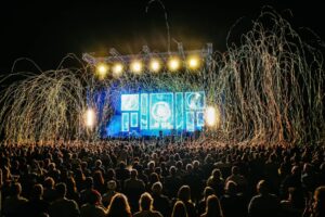 People look at a stage at an outdoor music festival