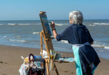 Things to Do This Weekend in Baltimore (Aug. 14-15) An old woman paints on the beach