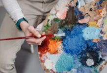Person painting with a palette covered in paint